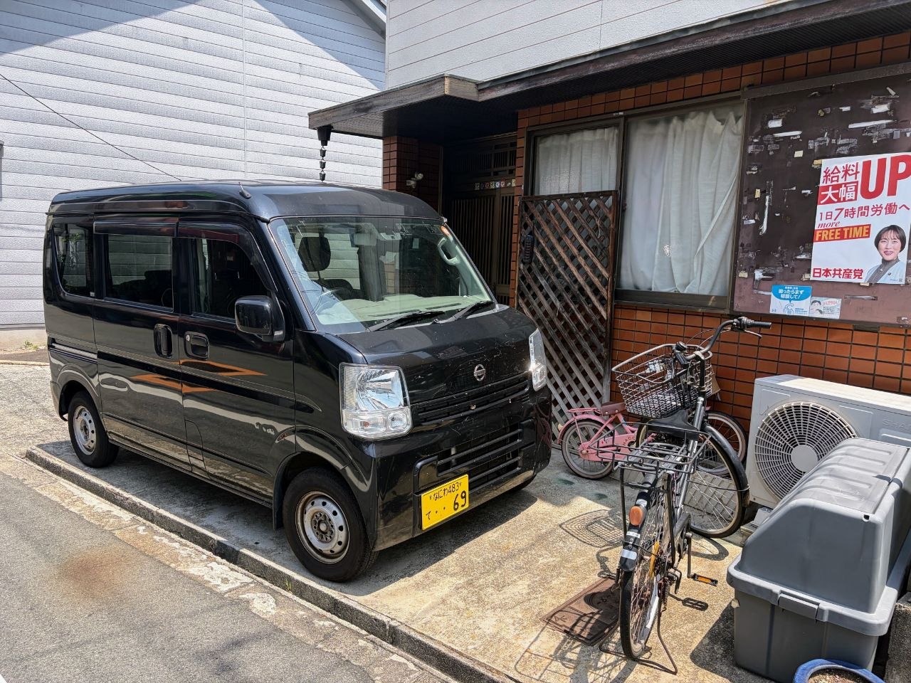Furgoneta, bicicletas y vivienda en un barrio de Osaka