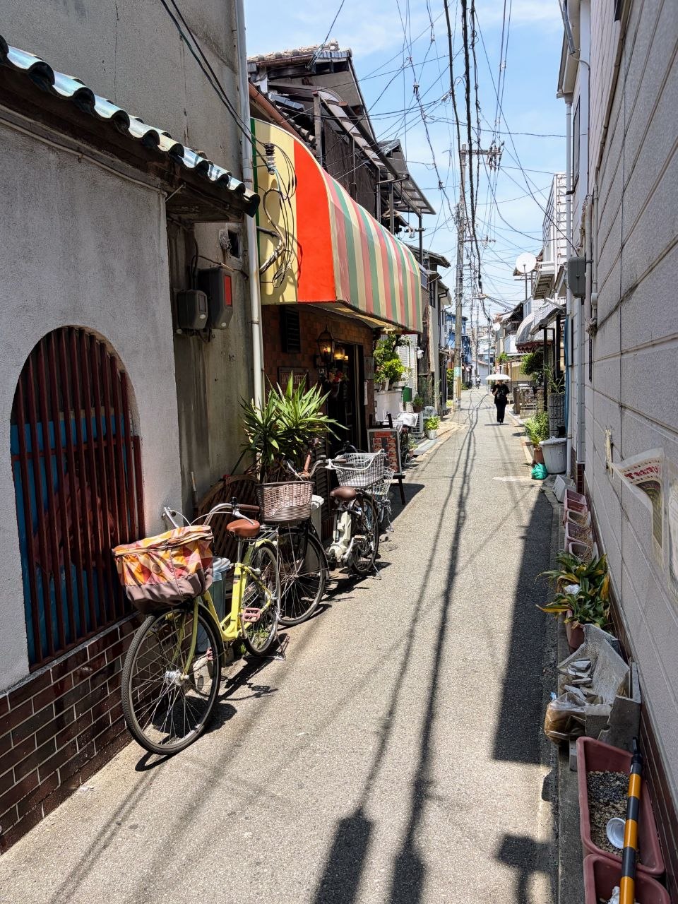 Calle estrecha residencial de Osaka con bicicletas y toldos