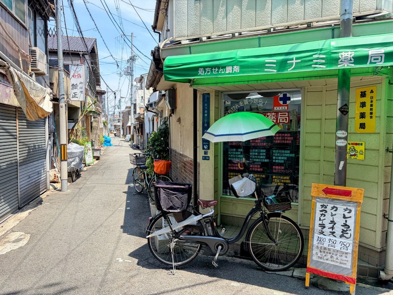 Farmacia verde en una calle residencial de Osaka