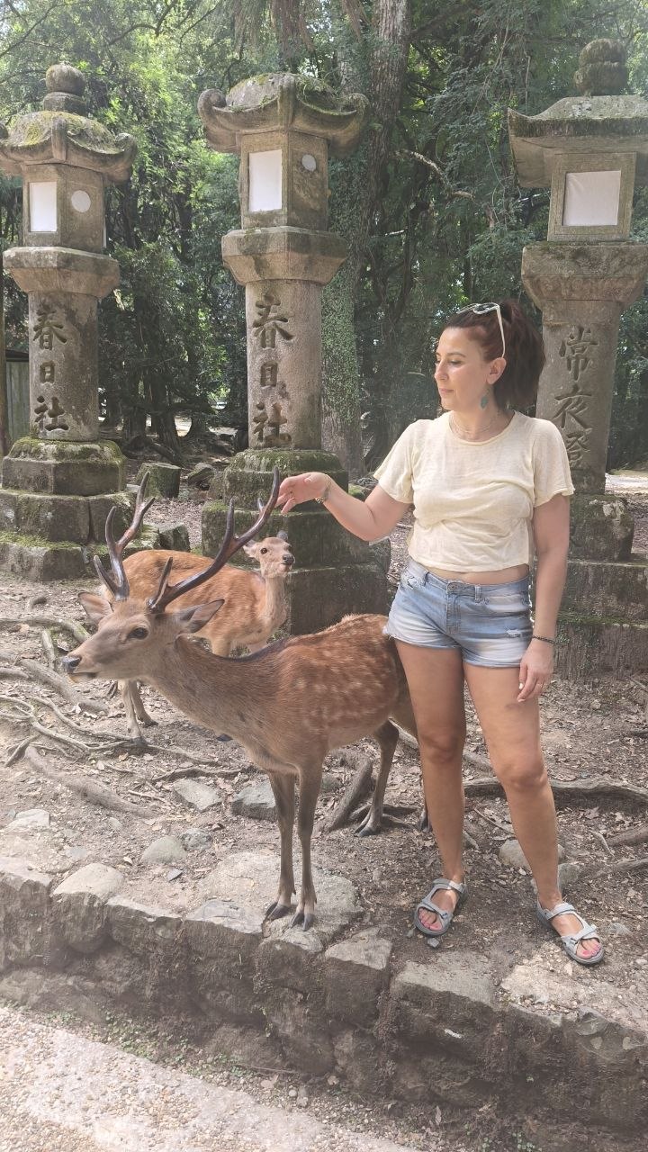 Vanessa junto a ciervos y faroles de piedra en Nara
