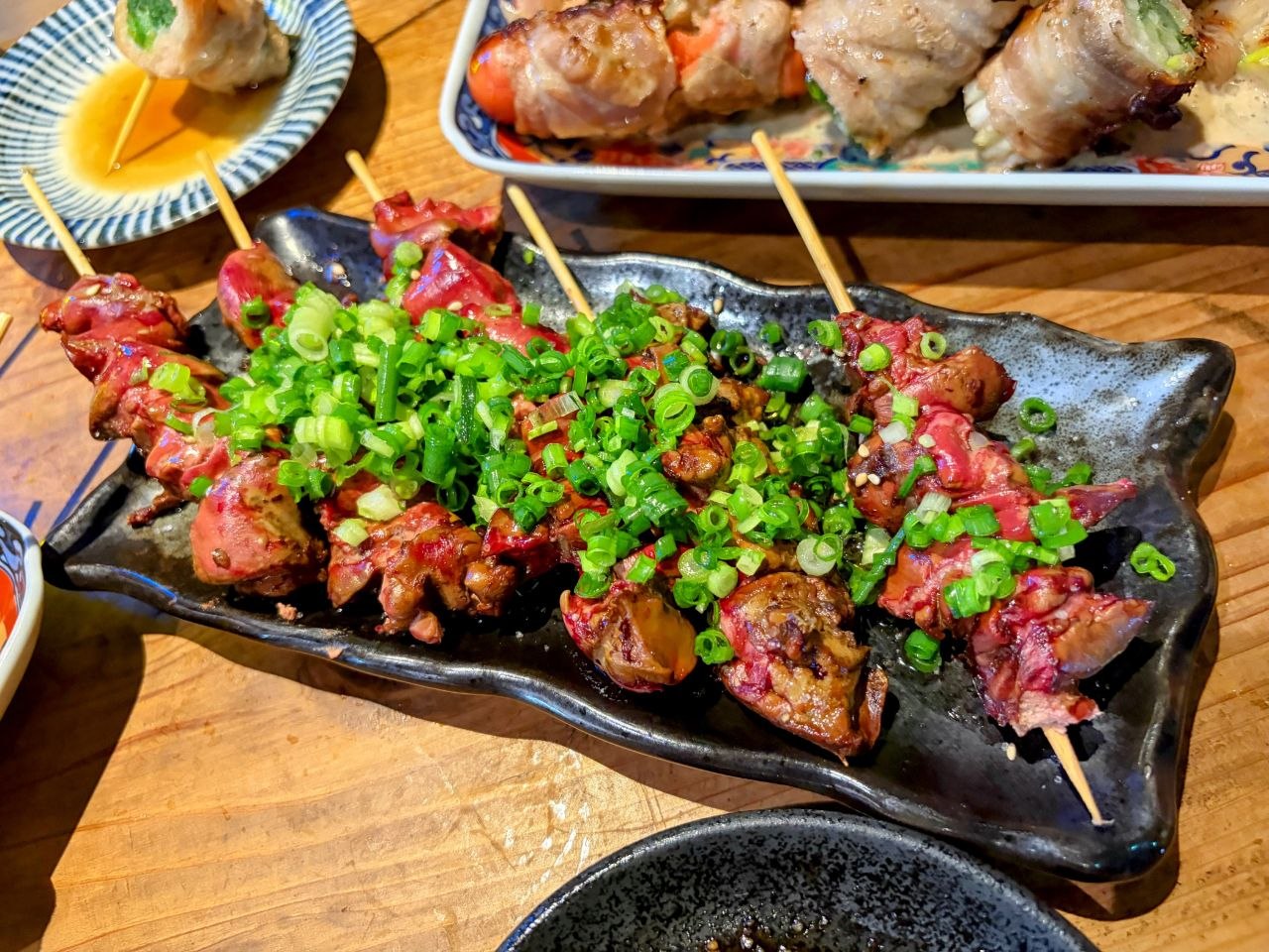 Brochetas japonesas con cebolleta en una mesa de Nipponbashi