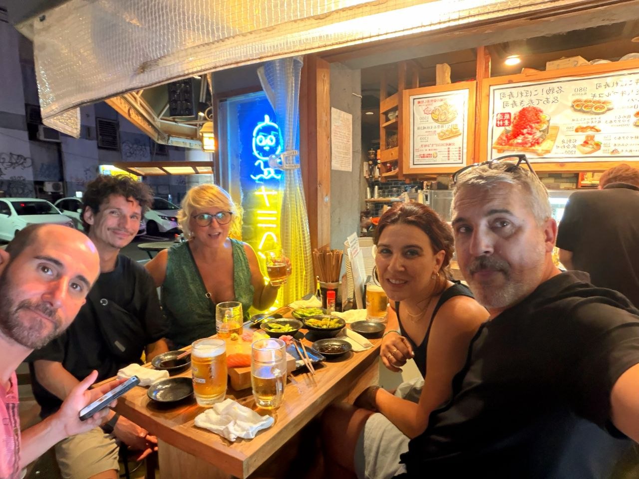 Selfie de grupo cenando al aire libre en Nipponbashi