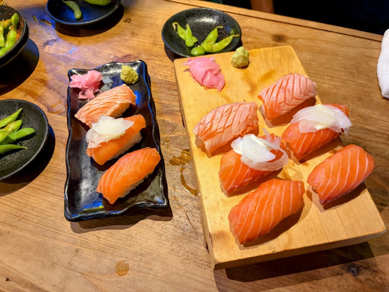 Nigiris de salmon y edamame sobre una mesa de madera en Nipponbashi