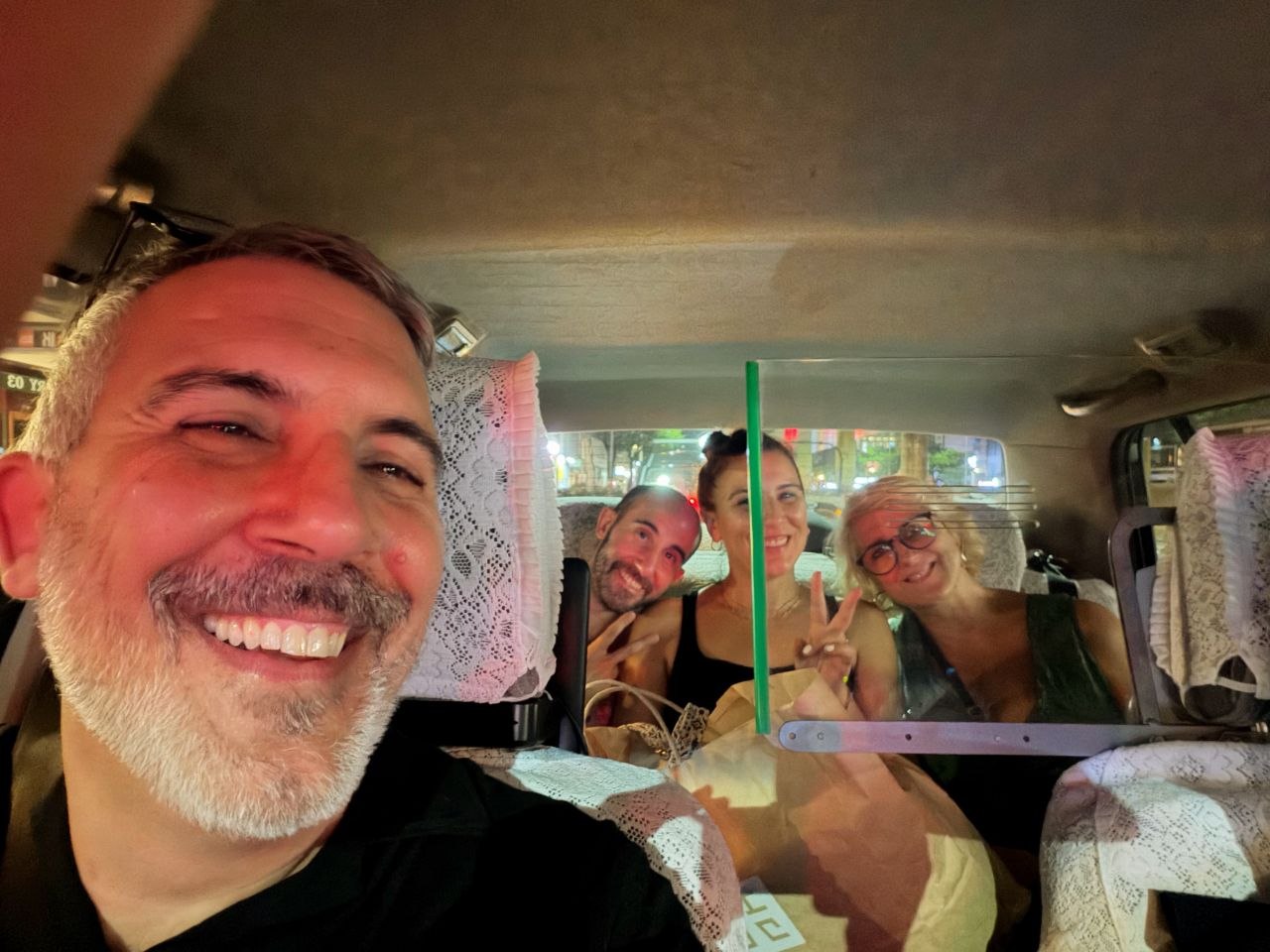 Selfie de grupo dentro de un taxi por la noche en Osaka