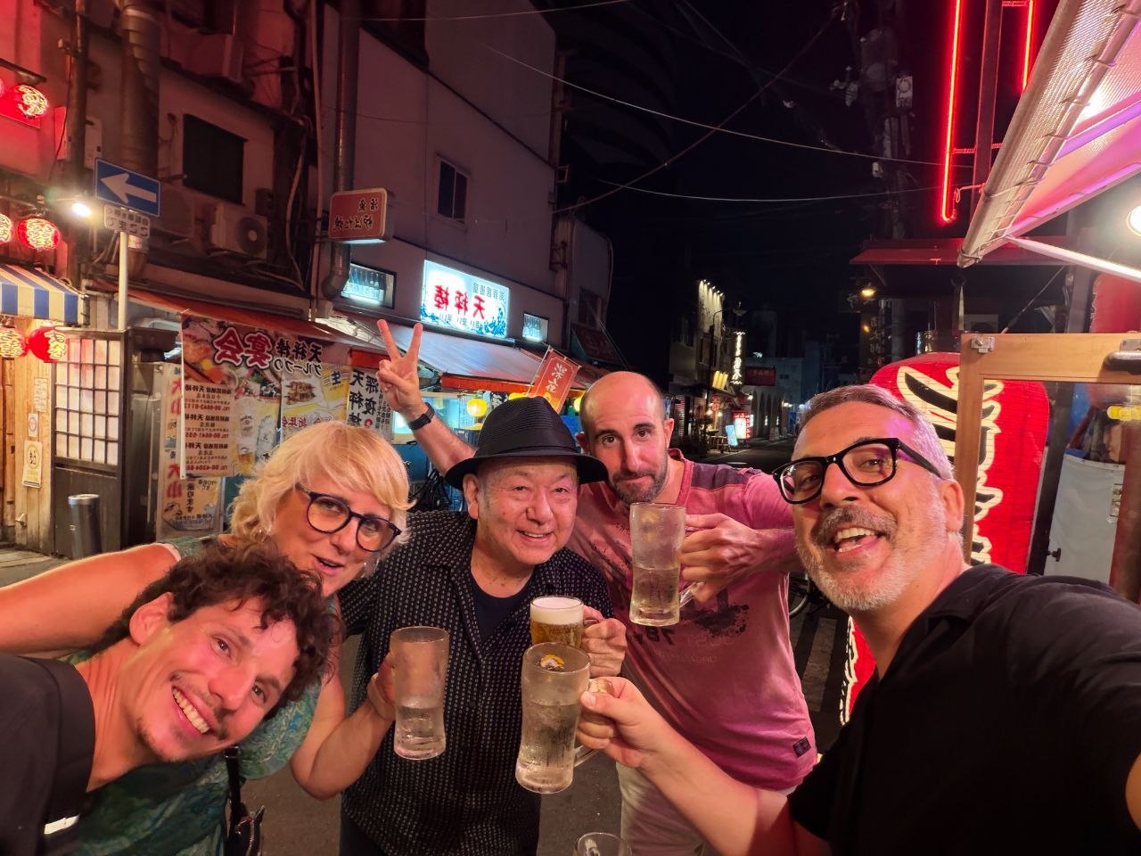 Brindis nocturno con un vecino local en una calle de Nipponbashi