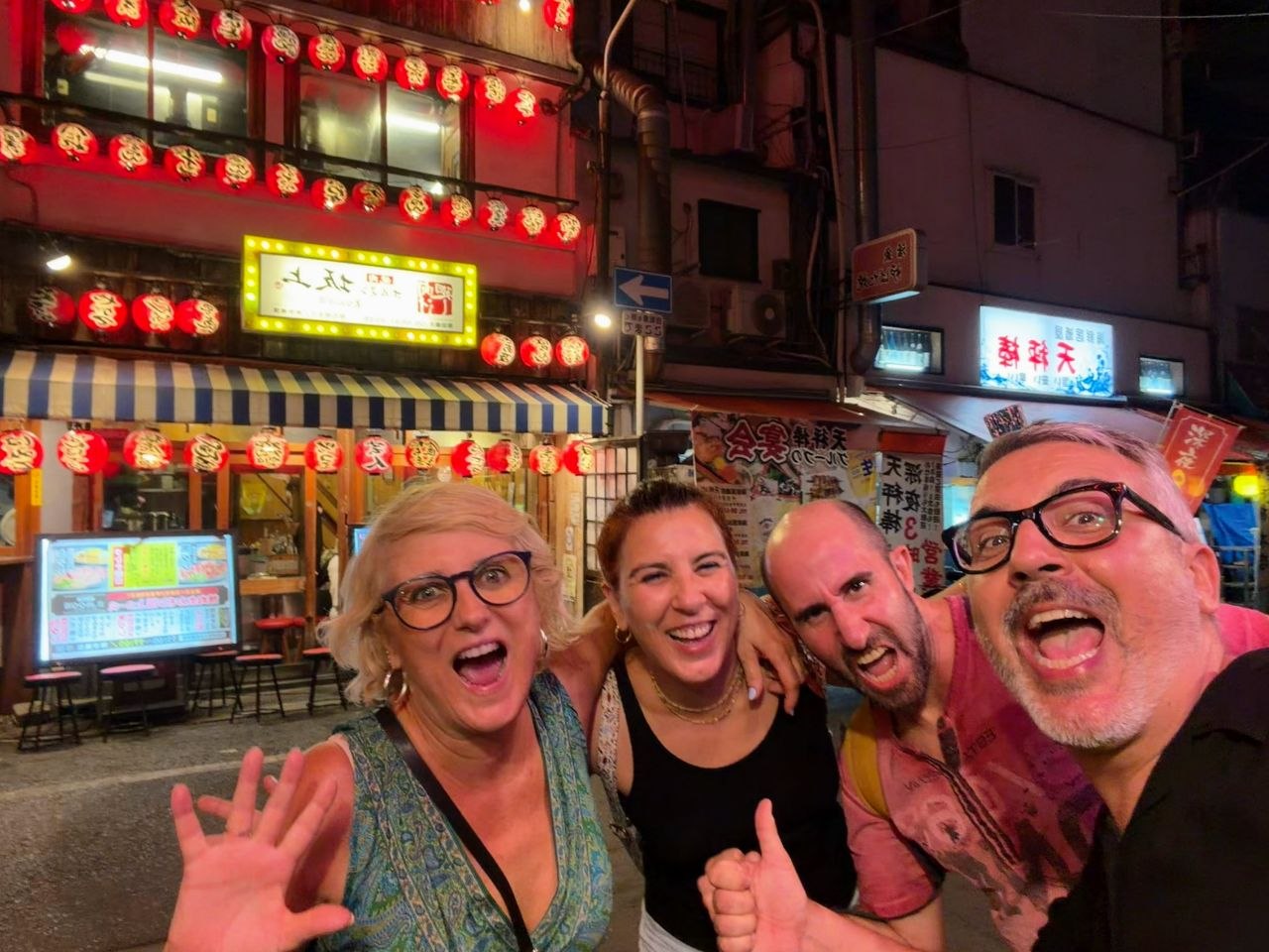 Selfie de grupo frente a restaurantes con faroles rojos en Nipponbashi