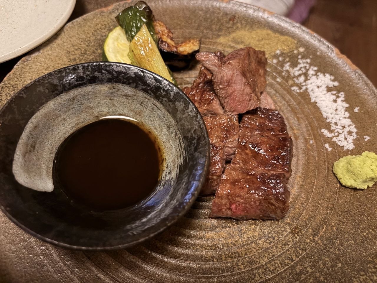 Plato de carne con salsa, sal y wasabi en restaurante de Kyoto