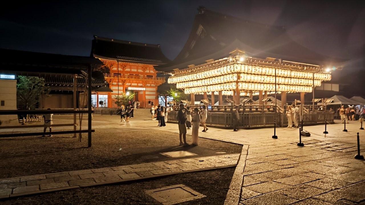 Santuario de Kyoto iluminado de noche con hileras de faroles blancos
