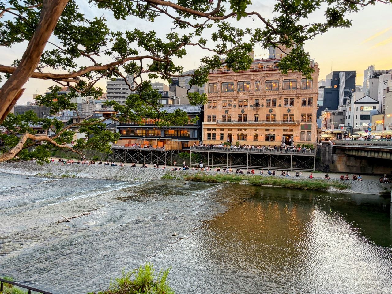 Rio Kamo al atardecer con terrazas y gente sentada junto al agua en Kyoto