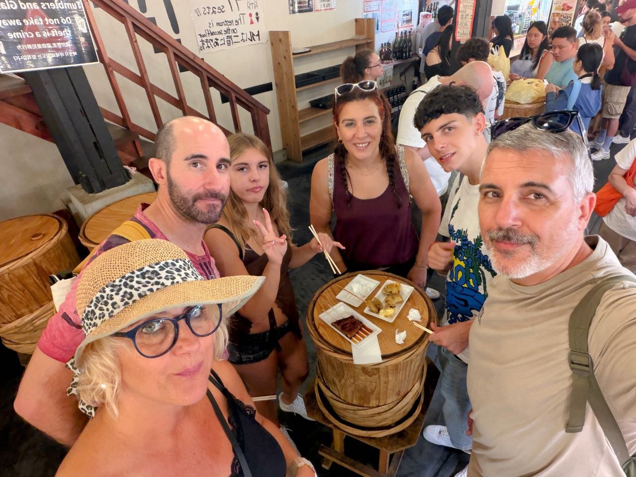 Selfie de grupo comiendo en Nishiki Market en Kyoto
