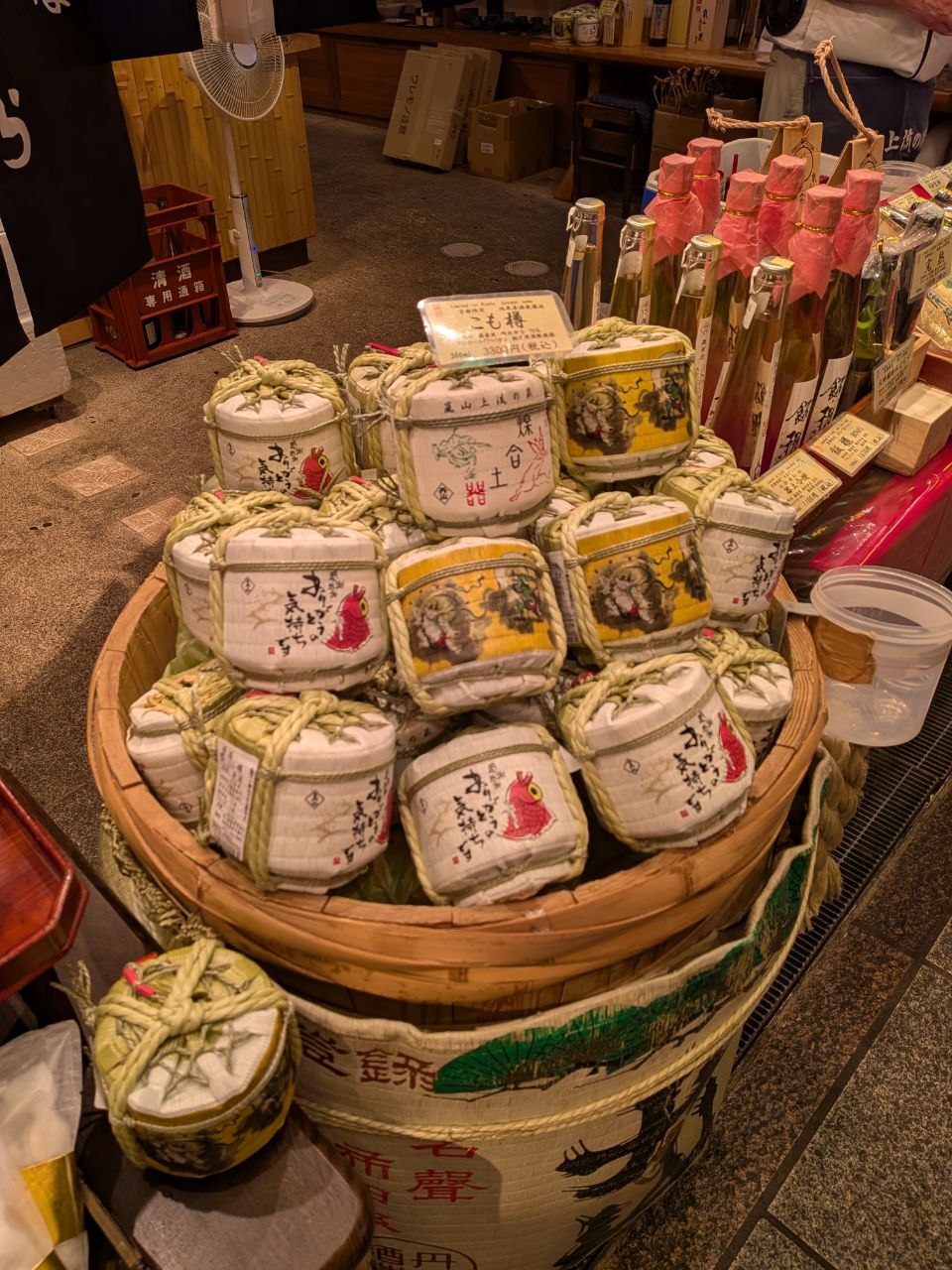 Barriles pequenos de sake y botellas en una tienda de Nishiki Market