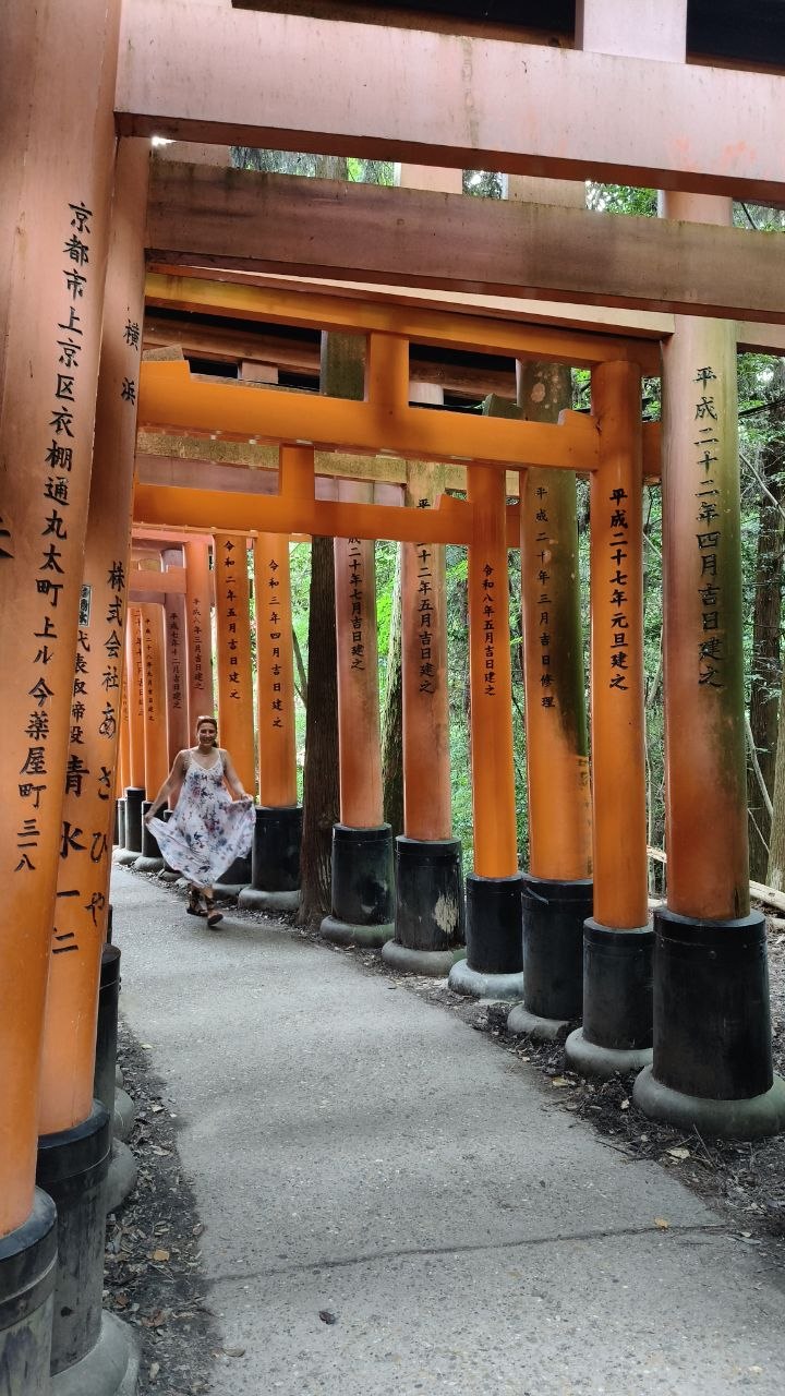 Vanessa bajo una galeria de torii rojos en Fushimi-Inari Taisha