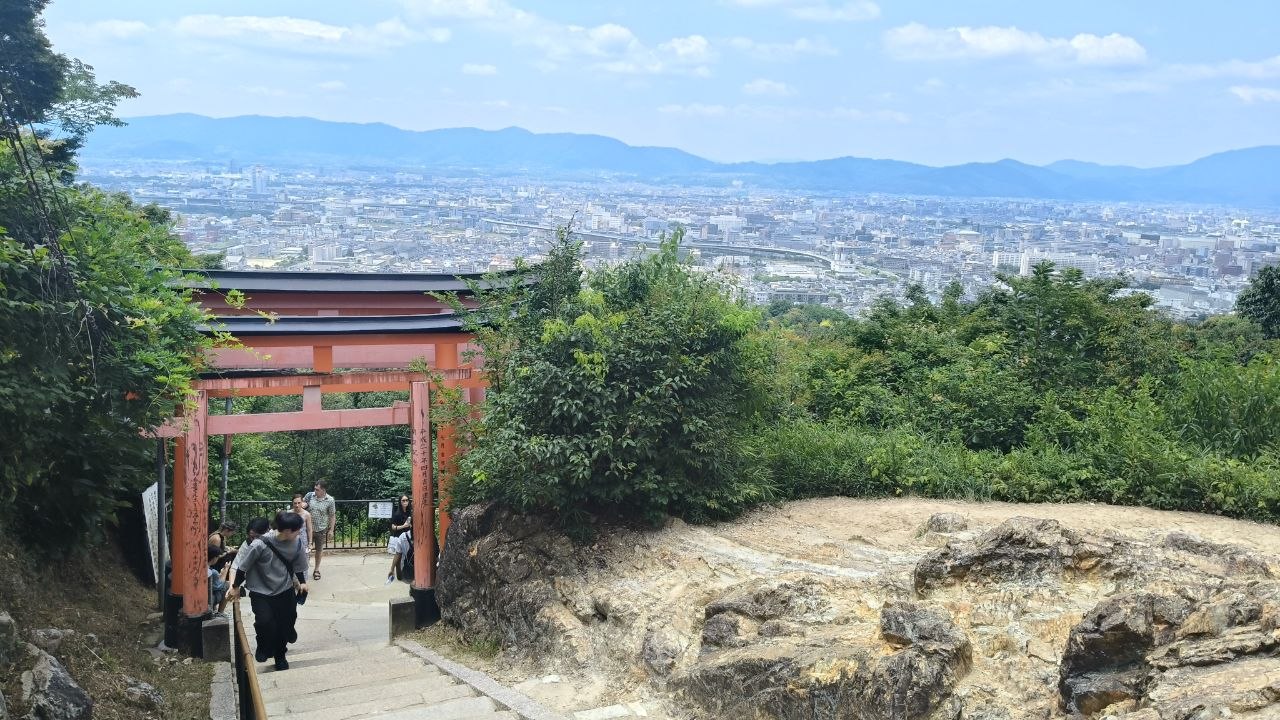 Vista de Kyoto desde la subida de Fushimi-Inari con un torii rojo en primer plano