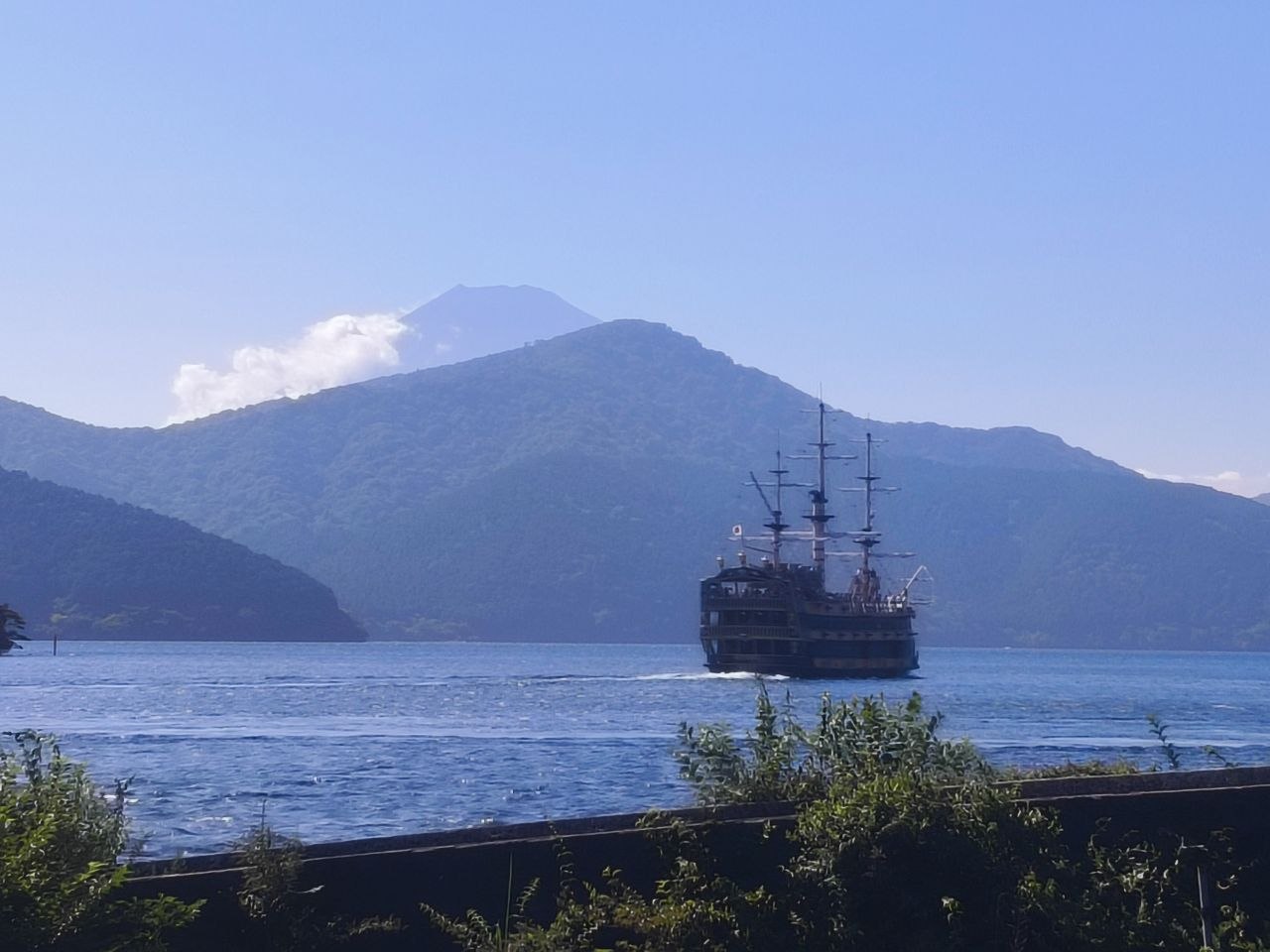 Barco pirata navegando por el lago Ashi con montanas y el monte Fuji al fondo